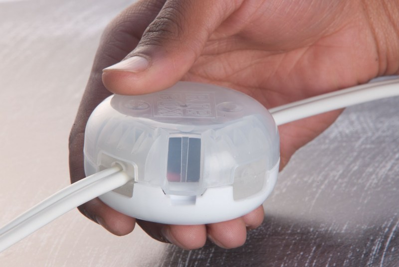 Hand installing a RIPBOX junction box over an existing connection